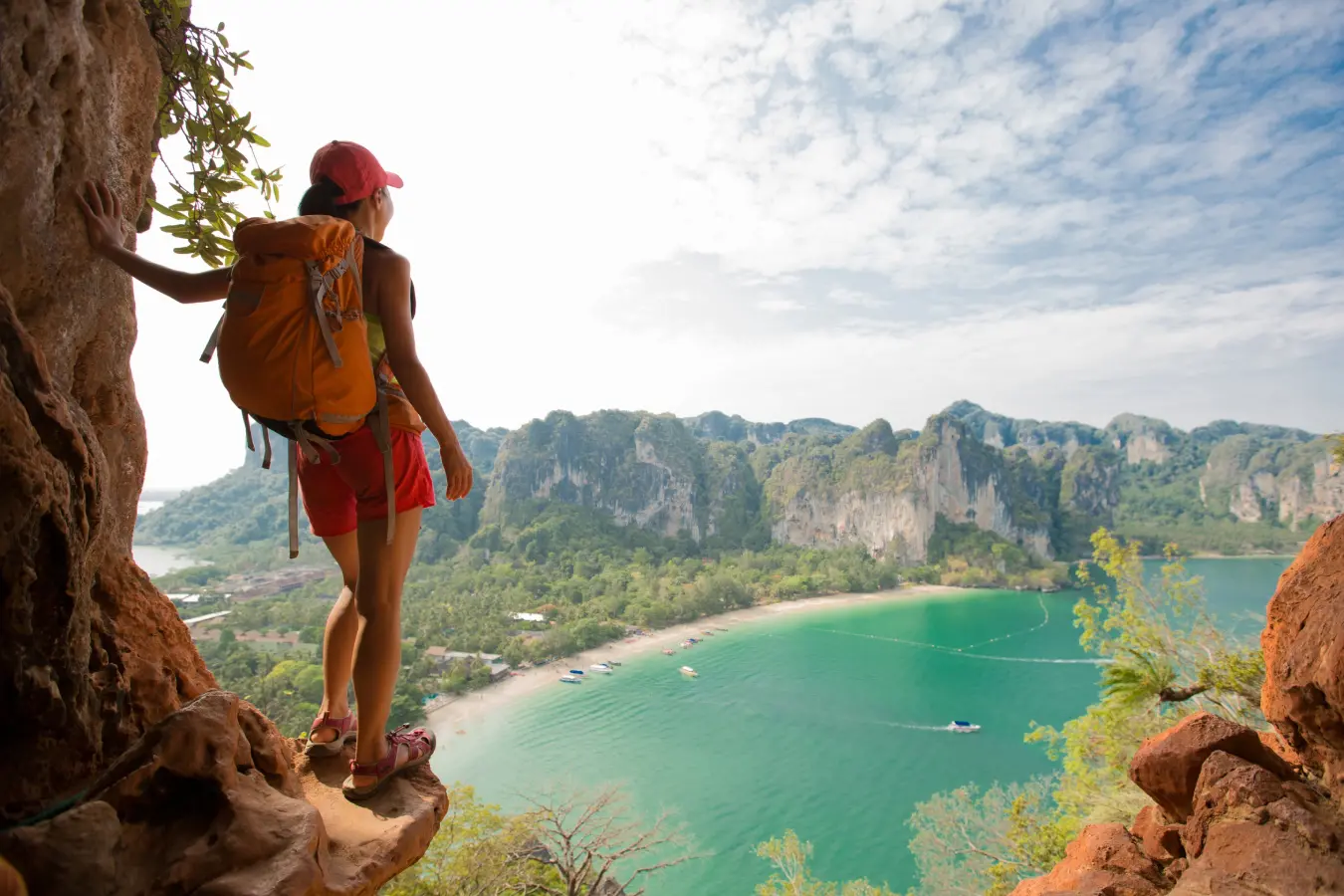 Hiker overlooking scenic bay and cliffs.