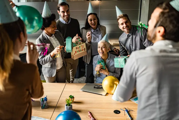 Large group of happy business people having fun while celebrating their colleagues Birthday in the office.