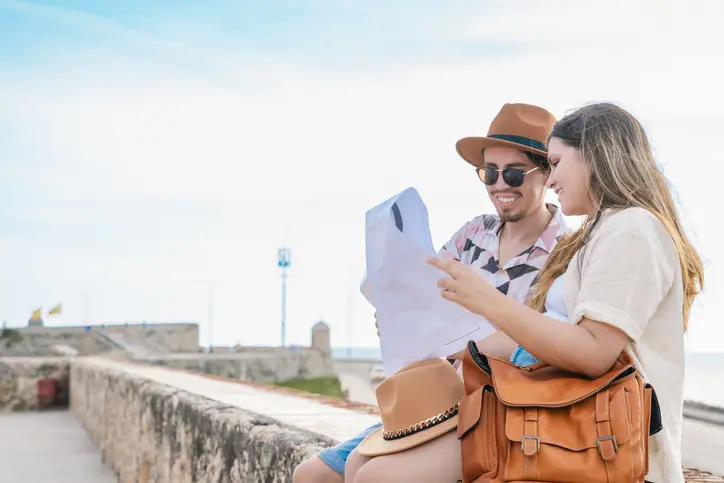 Traveler couple searching the map for famous places and pointing where she should go