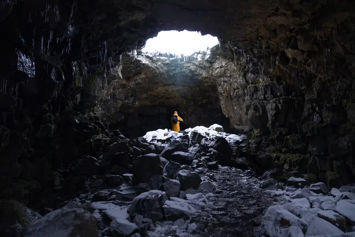 A man walking and exploring the cave