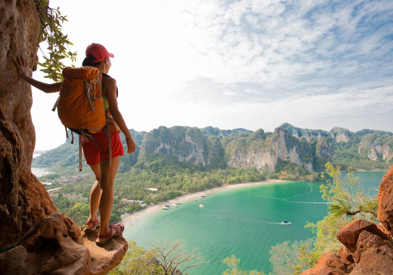 Hiker overlooking scenic bay and cliffs.